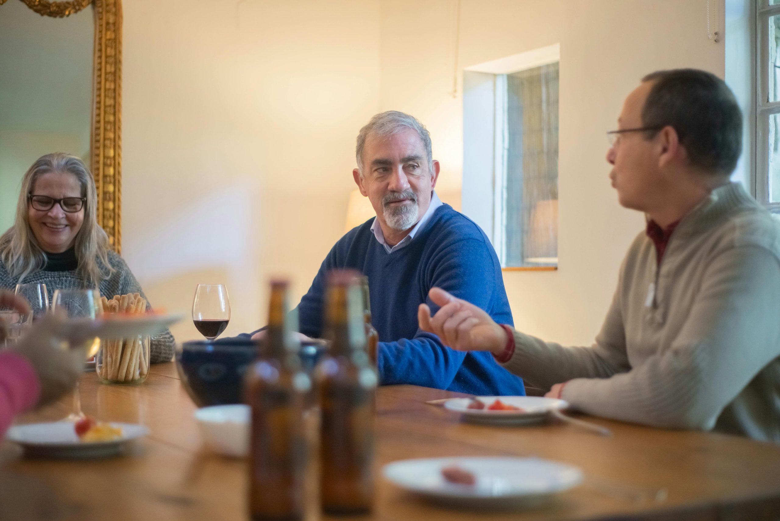 Adult children and aging parents having a thoughtful conversation around a dining table at home.